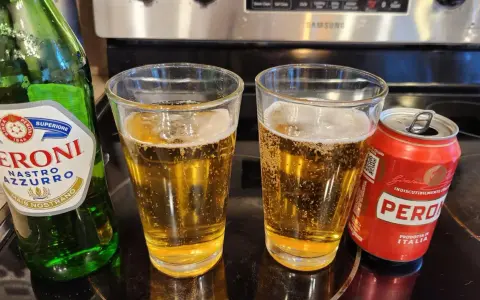 Dwa szklanki orzeźwiającego peroni piwo, obok zielona butelka i czerwona puszka. Idealne na włoskie popołudnie.