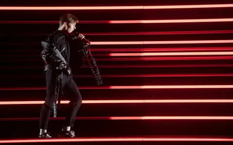 Benjamin Ingrosso på scenen med rött ljus som bakgrund, redo för Eurovision.