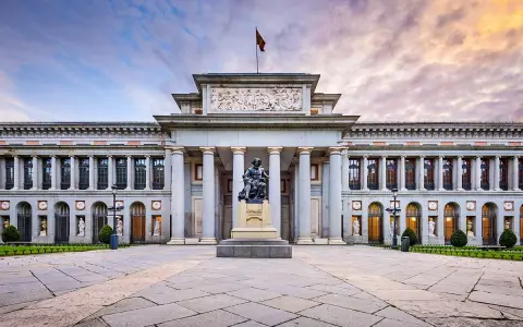 Przed majestatycznym muzeum w Madrycie, na placu z kamienną posadzką, stoi pomnik artysty.