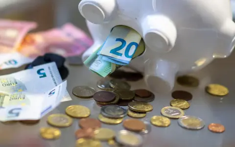Sparschwein mit Euro-Scheinen und Münzen. Vielleicht reicht es bald für free now taxi preise.