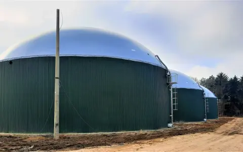 Zielone, cylindryczne zbiorniki z kopułami to biogazownia, gdzie powstaje energia z biomasy.