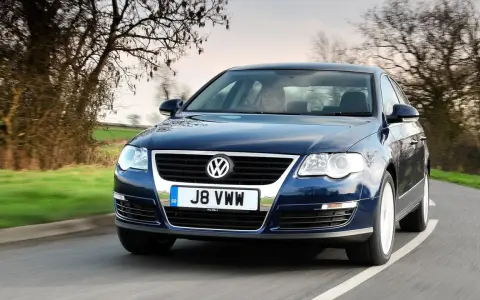Ciemnoniebieski Passat B6 jedzie po krętej drodze. Zastanawiasz się, jakie żarówki Passat B6 przód wybrać?