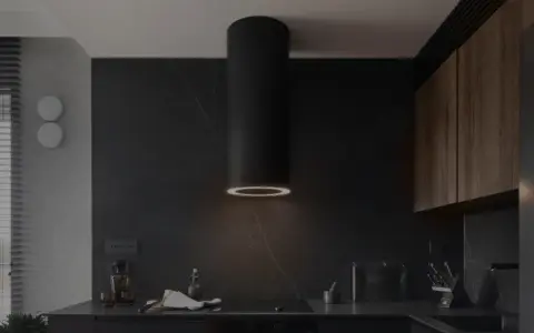 Nowoczesny okap kuchenny czarny z pierścieniem świetlnym nad płytą indukcyjną. W tle ciemne, kamienne ściany i drewniane szafki.