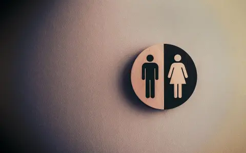 Symbol płci na tle ściany. Fizjoterapia uroginekologiczna dla każdego.