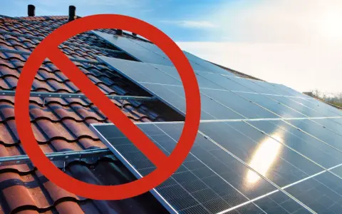 Rött stopptecken över solpaneler på ett tak. Ett svea solar problem som hindrar installationen.