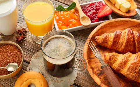 Pyszne śniadanie kontynentalne: świeże croissanty, dżemy, masło, sok pomarańczowy i kawa. Idealny początek dnia!