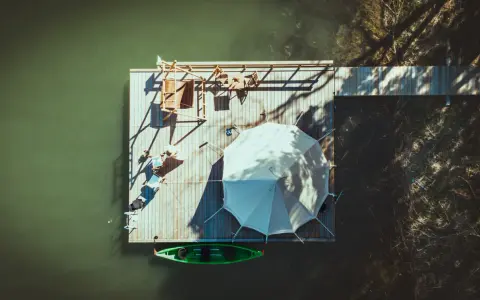 En flytande plattform vid Marholmen camping med tält, solstolar och en grön kajak.
