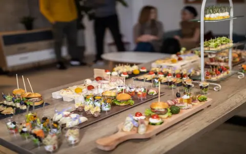 Stół pełen pysznych finger food: mini burgery, koreczki, przekąski w pucharkach. Idealne na imprezę!