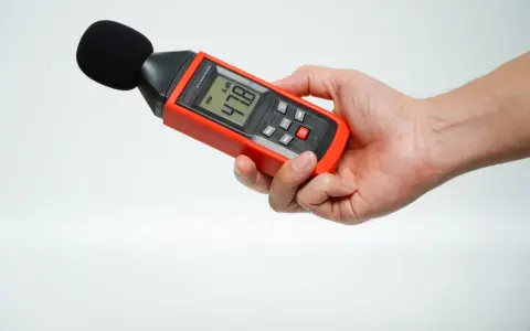 Main tenant une sonomètre pour savoir comment mesurer les décibels dans une pièce. L'appareil affiche 47.8 dB.