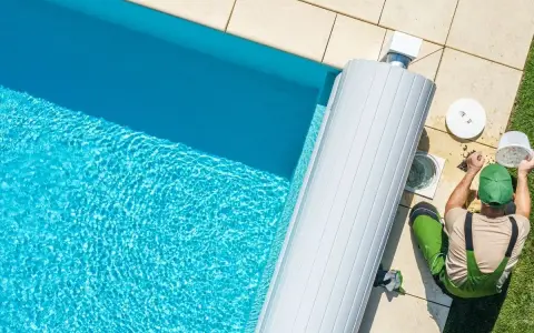 Un technicien nettoie le filtre de la pompe de piscine, un entretien essentiel pour optimiser la consommation d'énergie.