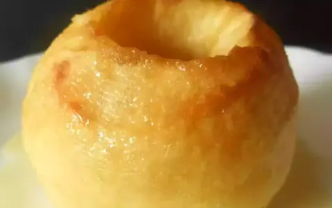 Une pomme au four dorée, creusée et prête à être garnie. Un délice simple et réconfortant.