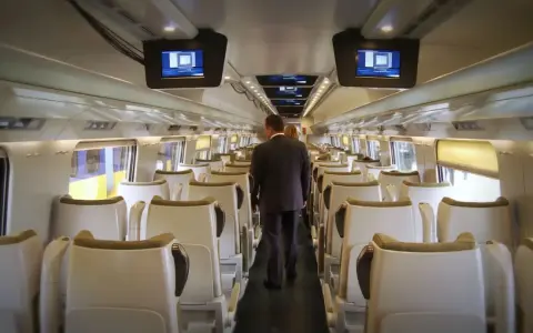 Wnętrze pociągu Pendolino. Para pasażerów idzie przez pusty wagon w drodze z Rzeszowa do Gdańska.