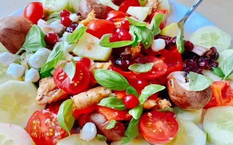 Salade colorée avec poulet, tomates, concombre, mozzarella et fruits rouges. Une excellente idée repas froid midi, fraîche et savoureuse.