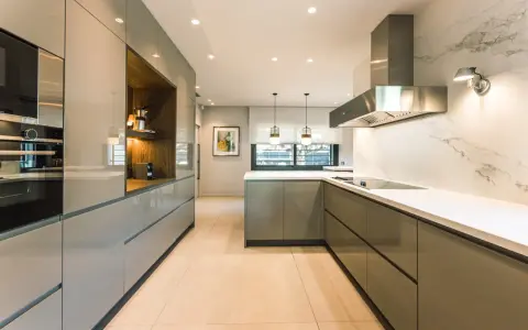 Elegantes diseños de cocinas modernas pequeñas, con gabinetes grises brillantes, encimeras blancas y electrodomésticos integrados.