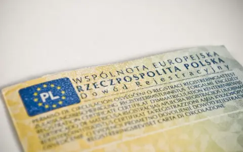 Dowód rejestracyjny pojazdu, niezbędny do ubezpieczenia samochodu, z flagą PL i tekstem w wielu językach.