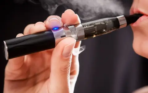 Persona usa un vaper saludable, exhalando vapor blanco.