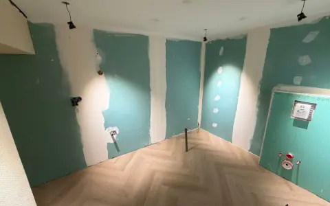 Chantier en cours : murs en Placo vert, sol parquet chevron. Idéal pour estimer le prix pose placo m2.