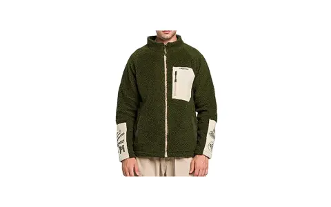Giacca sherpa verde Stüssy con tasca beige e dettagli grafici sulle maniche. Perfetta per un look urbano e casual.