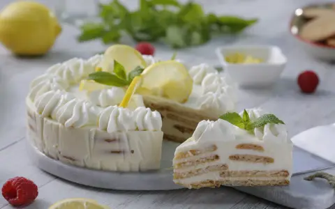 Pastel de limón con crema batida, rodajas de limón y menta.