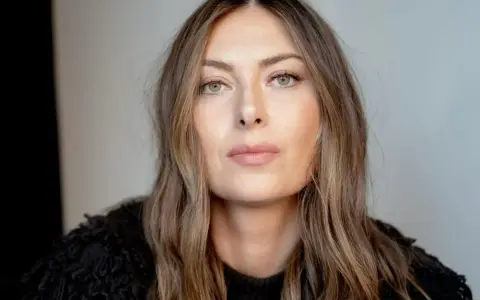 Kobieta z piwnymi oczami, o delikatnym spojrzeniu, w czarnym, futrzanym swetrze.
