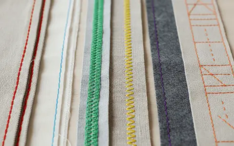 Bandes de tissus aux coutures variées : rouge, bleu, vert, jaune, violet et orange. Un aperçu de techniques de ruban couture.