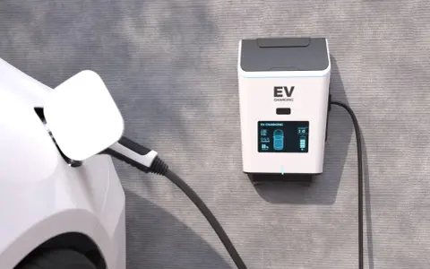 Biały samochód elektryczny podłączony do ładowarki EV na ścianie.