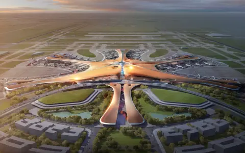 Futurystyczny terminal lotniczy, przypominający rozgwiazdę, z licznymi samolotami na płycie. To wizja największego lotniska na świecie.
