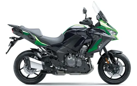 Czarny motocykl Kawasaki Versys 1000 z zielonymi akcentami, gotowy na przygodę.