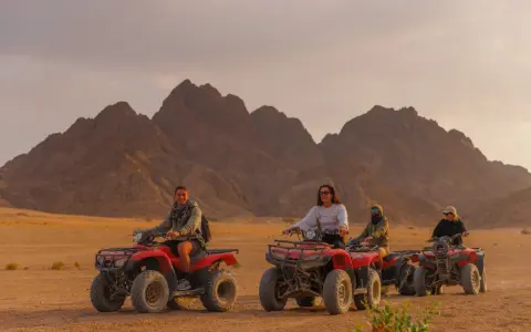 Un gruppo di persone si diverte in quad nel deserto egiziano, un'avventura indimenticabile a Sharm el Sheikh con bambini.