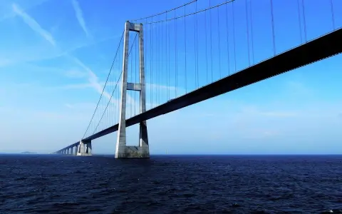 El puente del Gran Belt se extiende majestuosamente sobre el mar azul bajo un cielo despejado.