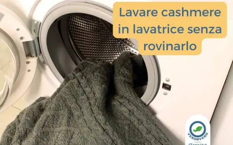 Un maglione di cashmere grigio viene inserito in una lavatrice. Impara come si lava il cashmere in lavatrice senza rovinarlo.