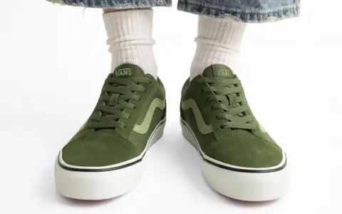 Zielone trampki Vans z jasną falą. Czy to rozmiar buta 11.5 cm? Białe skarpetki i podarte jeansy dopełniają stylizację.