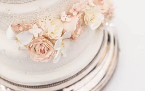 Elegancki tort weselny z różami i koronką. Sprawdź, jaka jest tort weselny cena, by zaplanować idealne przyjęcie.