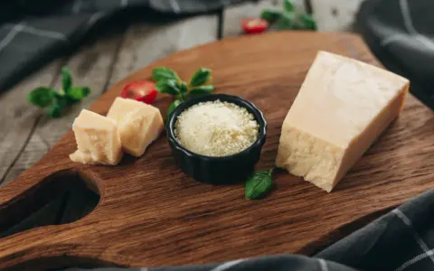 Kawałek parmezanu i starty ser w miseczce, idealne do carbonary, gdy szukasz alternatywy dla parmezanu.