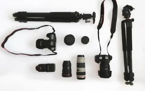 Ensemble d'un appareil photo reflex, d'objectifs, d'un flash et de trépieds, prêt pour une séance photo.