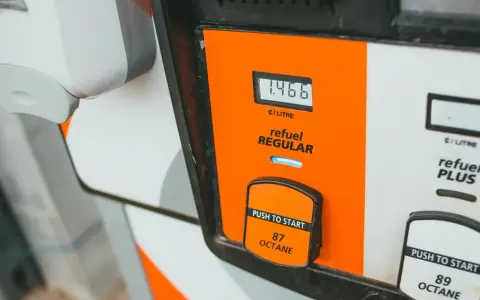 Zbliżenie na dystrybutor paliwa z wyświetlaczem ceny i przyciskiem "Push to Start".
