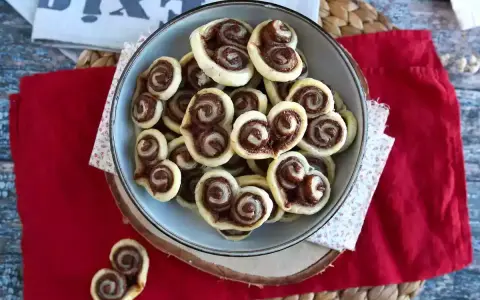 Cuoricini di pasta sfoglia rettangolare con Nutella, un dolce goloso pronto da gustare.