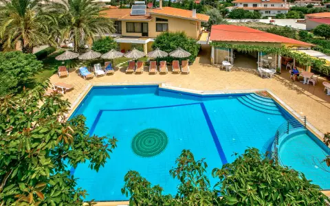 Basen hotelowy na Rodos, z leżakami i parasolami. Idealne miejsce na relaks pod słońcem.