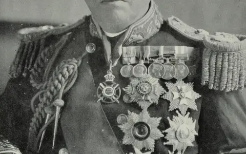 John Fisher trägt eine prunkvolle Uniform mit vielen Orden und Auszeichnungen.