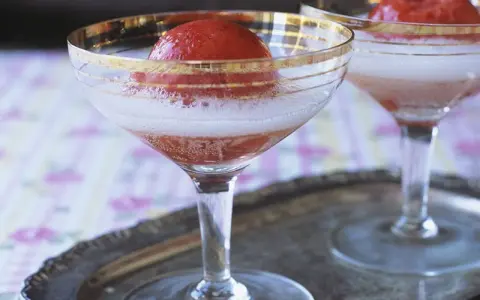 Zwei Gläser Champagner mit Erdbeeren, die auf einem Silbertablett stehen. Ein erfrischender Genuss.