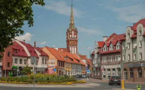 Kętrzyn atrakcje: malowniczy rynek z charakterystyczną wieżą kościelną, kolorowe kamienice i zielone skwery.