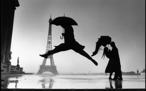 Parigi sotto la pioggia: una silhouette salta con un ombrello, mentre una coppia balla. Le foto più belle di sempre.