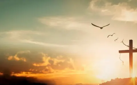 A cross on a hill, adorned with thorns, stands against a sunset sky. Birds fly overhead, symbolizing the feast of the exaltation of the holy cross.