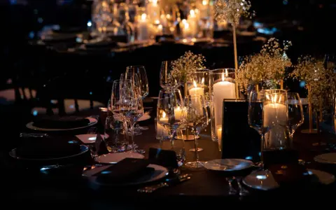 Une élégante mise de table à la française, illuminée par des bougies et des fleurs délicates, promet une soirée mémorable.