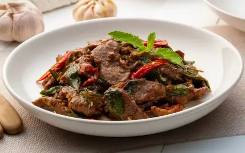 Aksamitne kawałki wołowiny w aromatycznym sosie z bazylią i chili. Pyszne wołowina po tajsku, gotowa do podania.