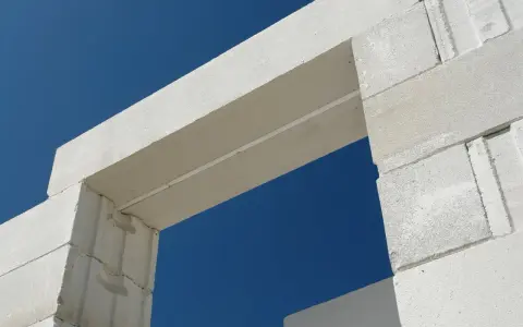 Białe nadproże nad drzwiami 90, wykonane z bloczków z betonu komórkowego, na tle błękitnego nieba.