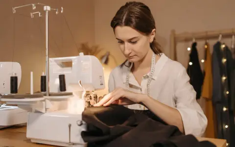 Une couturière utilise une surjeteuse pour créer un patron housse de chaise Burda.
