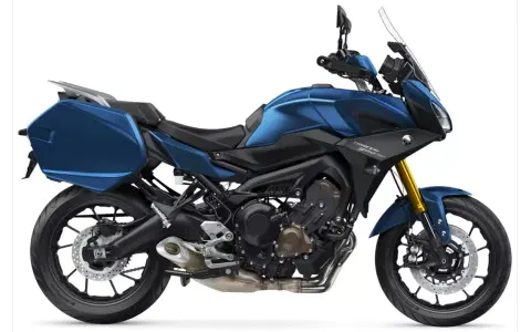 Niebieski motocykl Yamaha Tracer 900 GT z kuframi, gotowy na dalekie podróże.