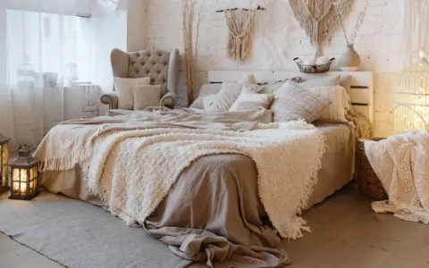 Acogedora decoracion boho habitacion con cama mullida, sillón, macramé y faroles.