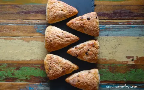 Sechs dreieckige Schokoladen-Scones liegen auf einem rustikalen Holztisch. Perfekt für alle, die keine komplizierten discard rezepte mögen.